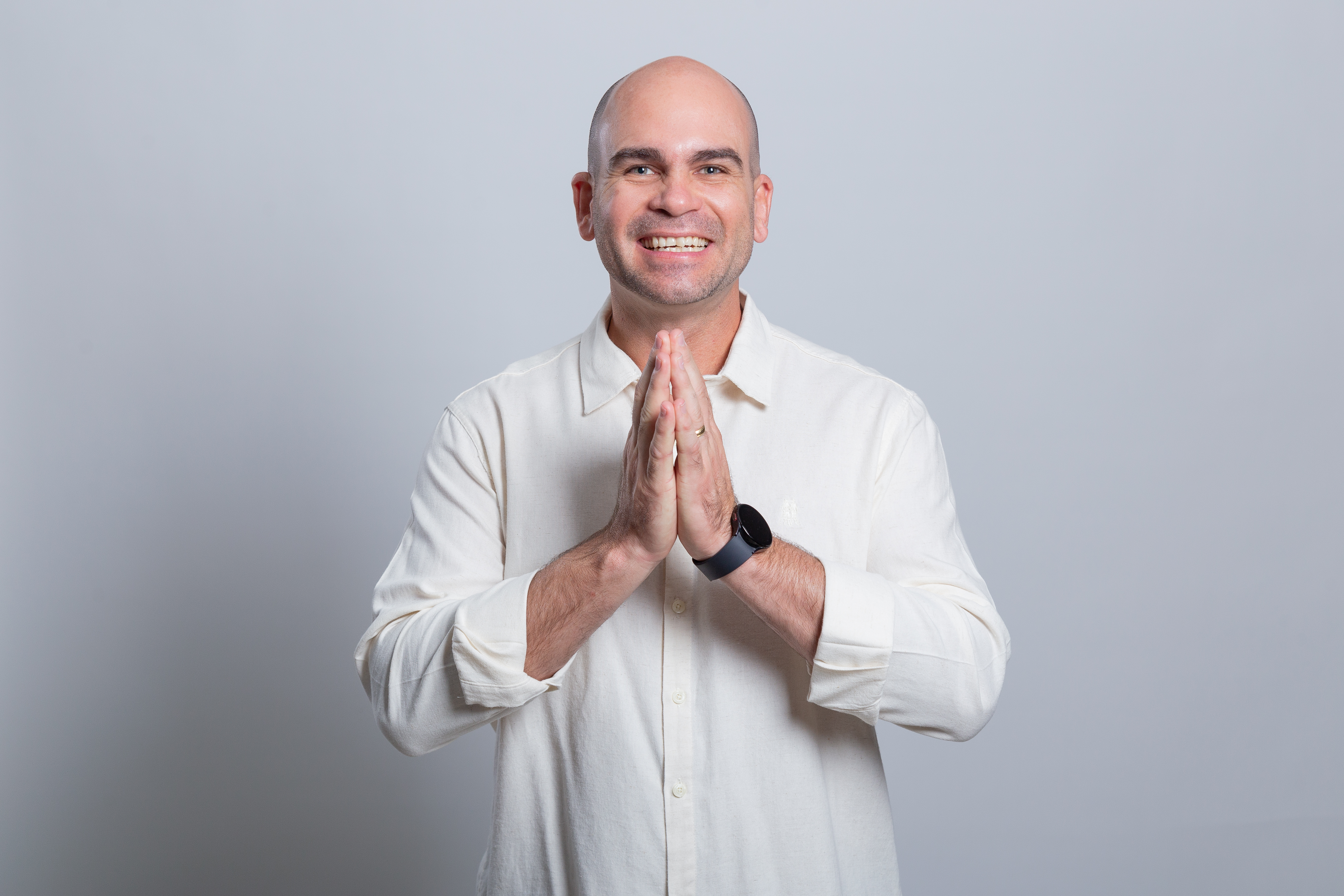 Felipe Lapa sorrindo com mãos unidas em gesto de gratidão